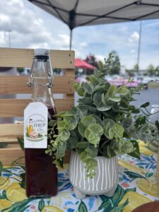 blackberry simple syrup from simply syrup by Yuri on a lemon cloth with a fake leaf plant