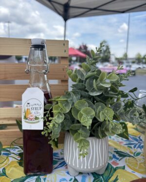 blackberry simple syrup from simply syrup by Yuri on a lemon cloth with a fake leaf plant
